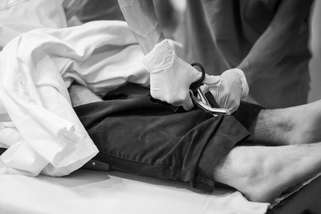 Patient's pants are cut off to expose possible injuries