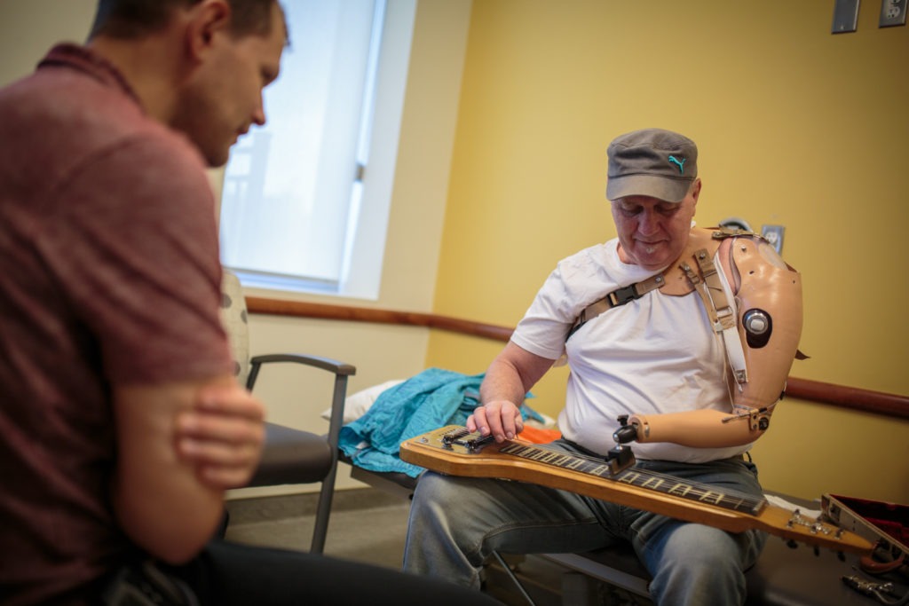 A patient provides feedback on how the guitar piece is progressing and what improvements can be made to help with his specific style of playing.