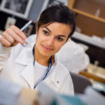 A medical laboratory technologist inspects tissue