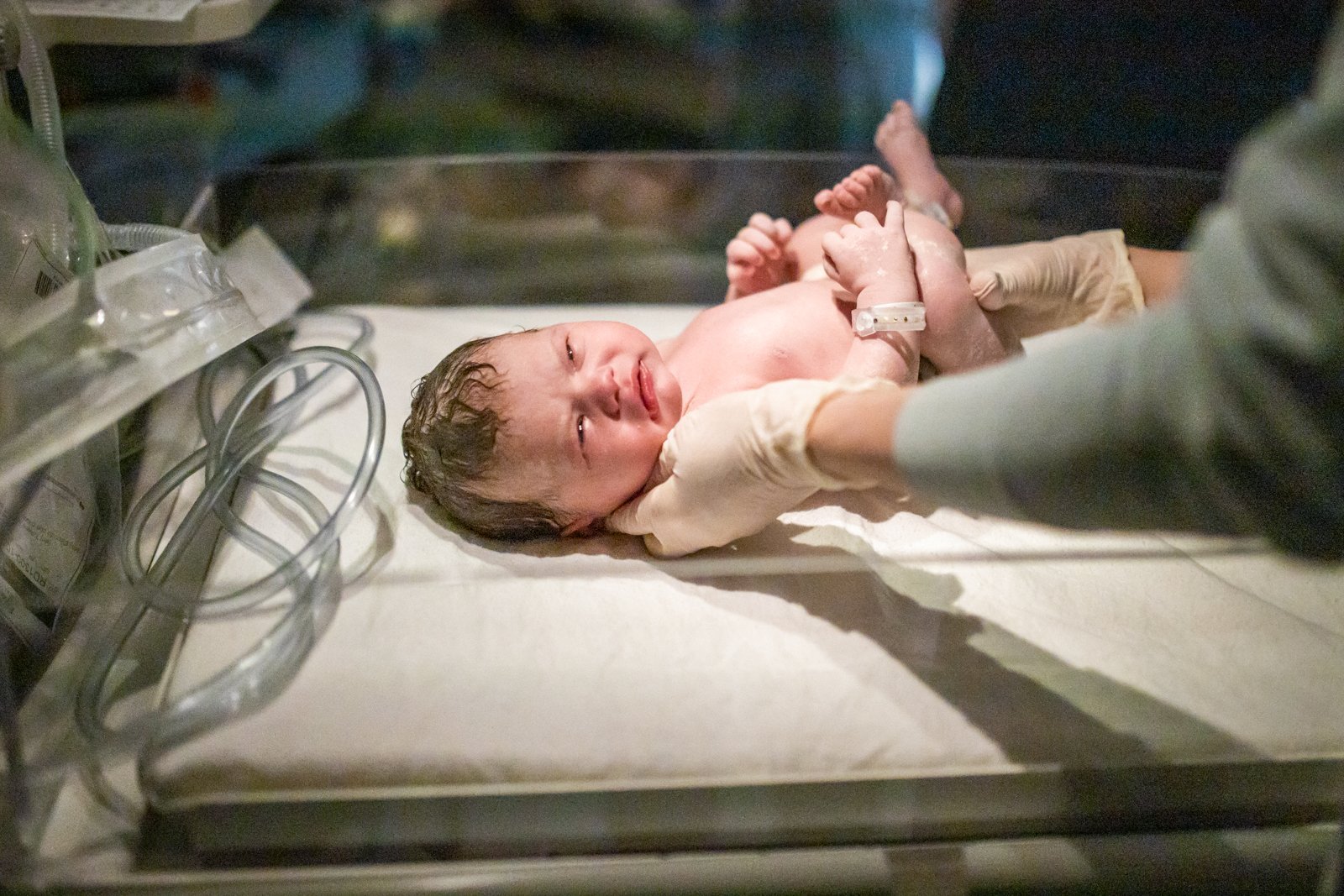 A new born baby is weighed on a scale
