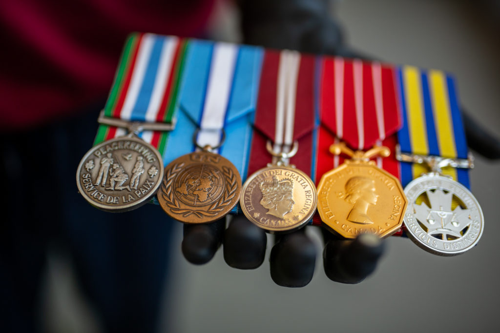 Craig holds his medals in his myoelectric hand