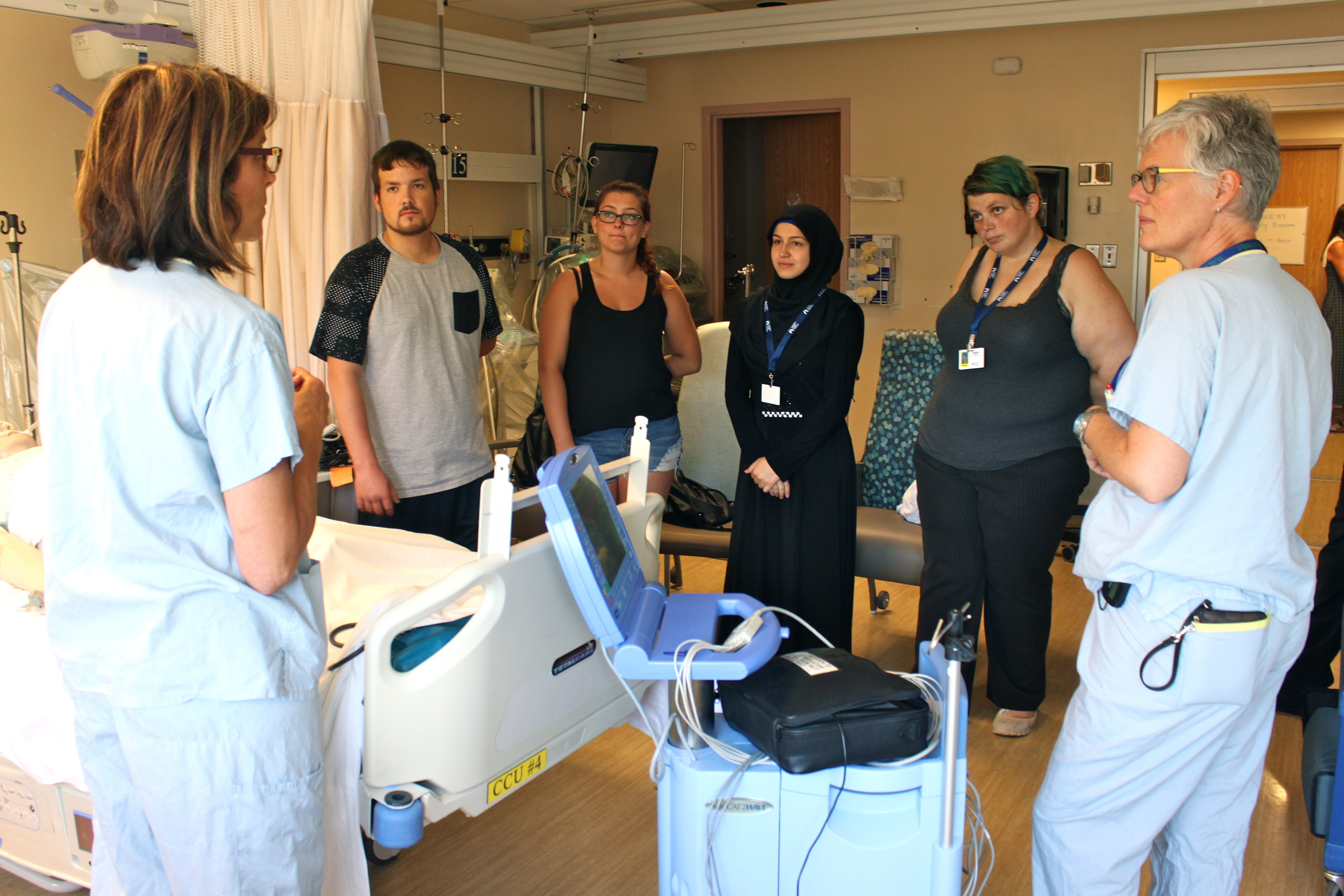 students listen as ICU staff explain patient care using a simulation mannequin