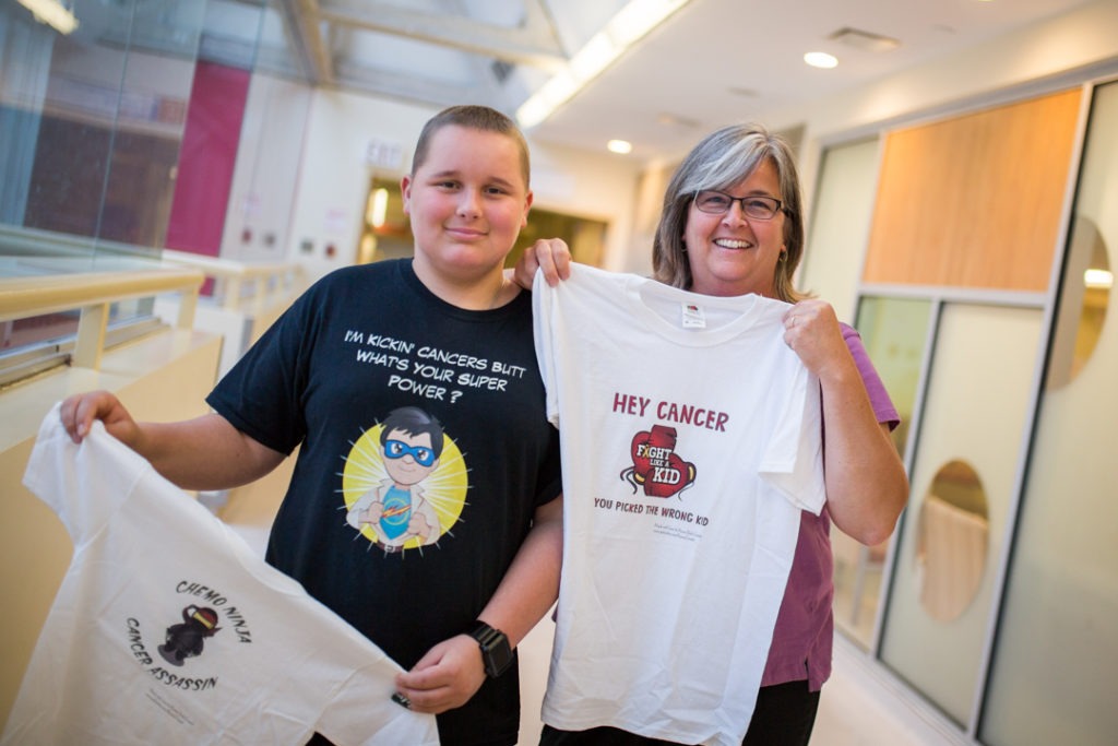 Karter Ellis an Joann Duckworth hold up their shirts with inspirational sayings