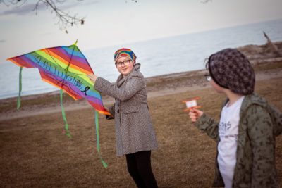 Lilly flies a rainbow kite with her sister, Scarlet