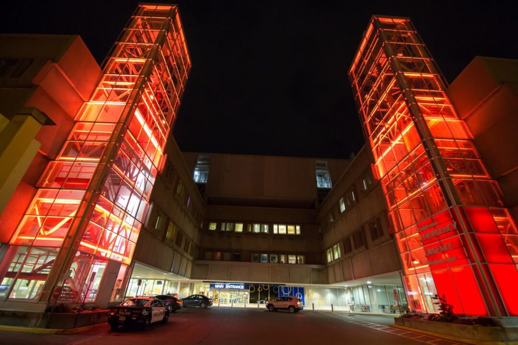 Red lights illuminate the towers at the front of McMaster Children's Hospital
