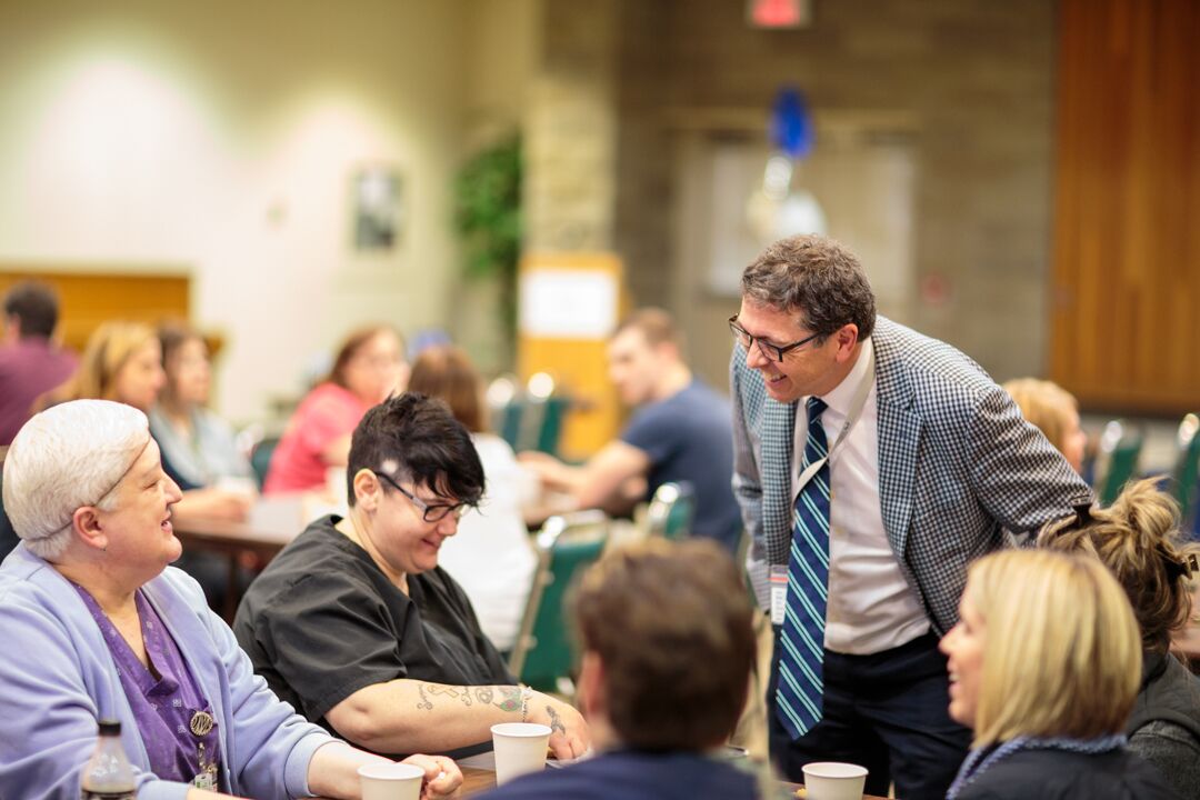Dr. Wes Stephen talking to staff at a table