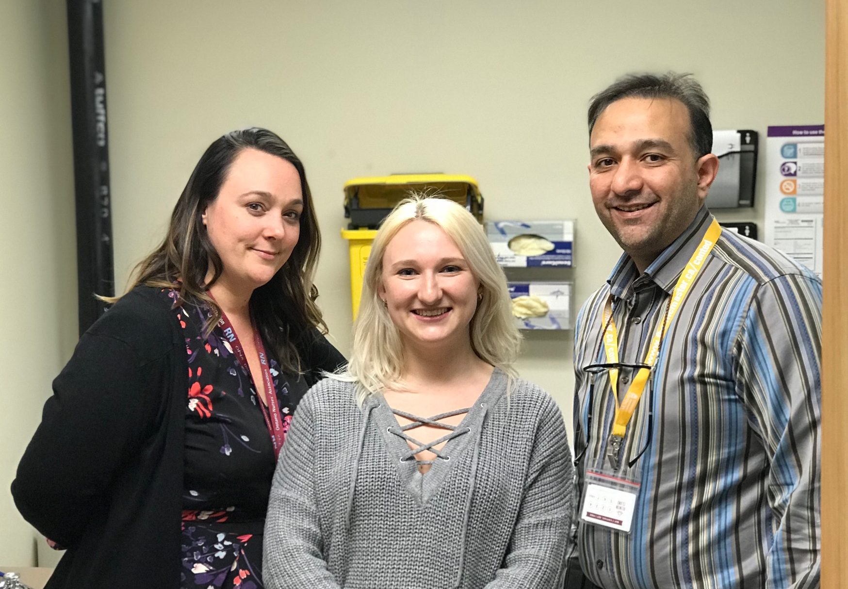 Nurse Ashley Fournier, patient Katie McMurrough and Dr. Ahmed Attar pose together in an exam room