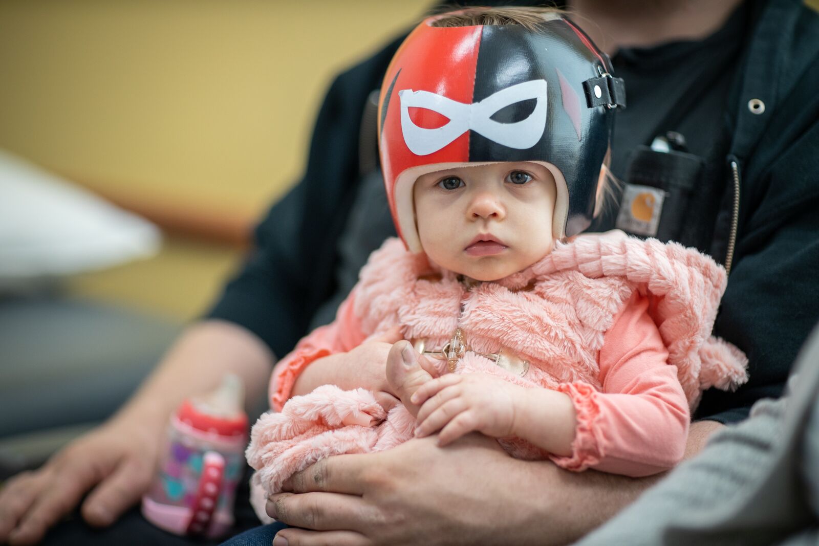 A baby wearing a black and red helmet