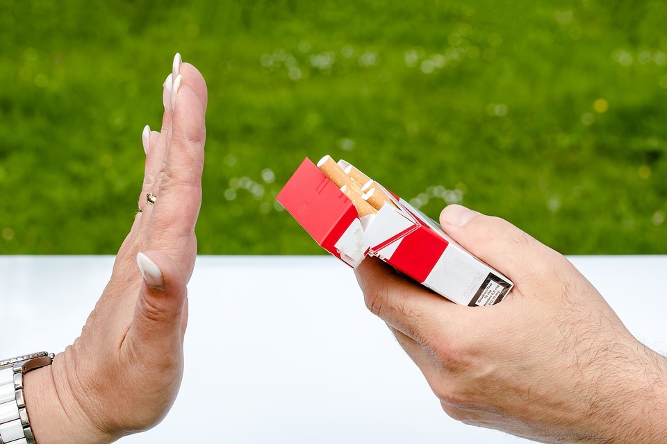 a woman holds up her hand, declining a cigarette
