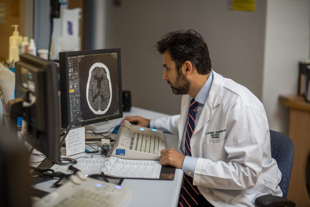 researcher analyzing a brain scan after a stroke