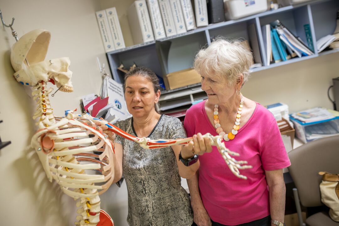 Esther McEvoy shows patient, Sandra Gmell, the shoulder joint on a skeleton