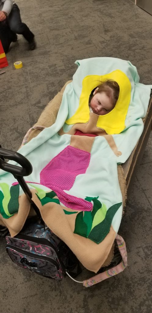 little girl in a wagon wearing mermaid costume