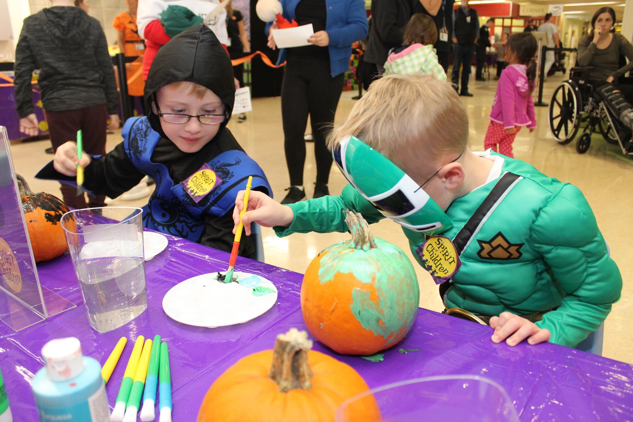 Two children doing crafts in costume