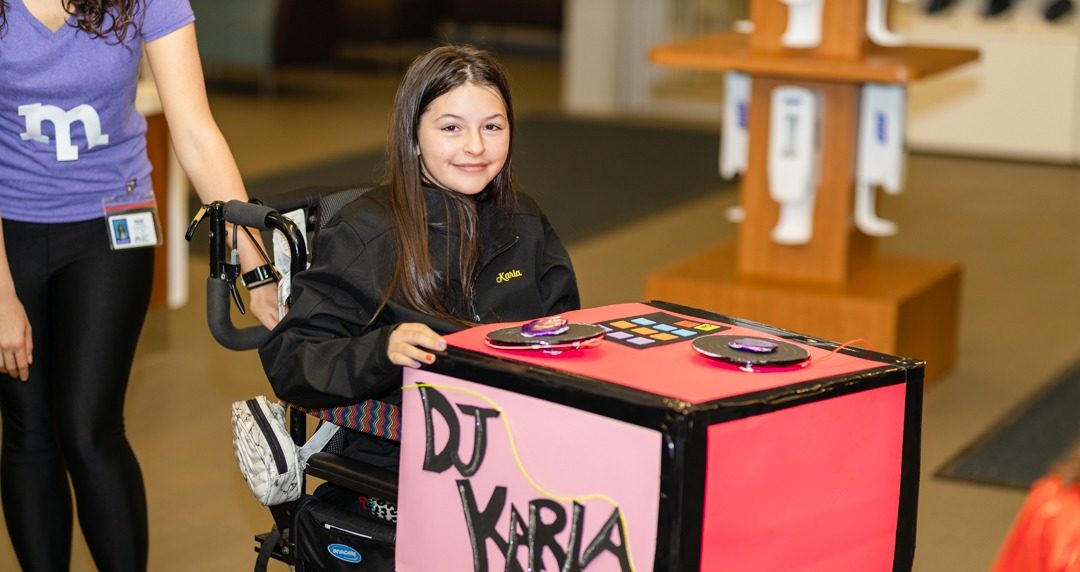 girl in wheelchair with DJ table on her lap