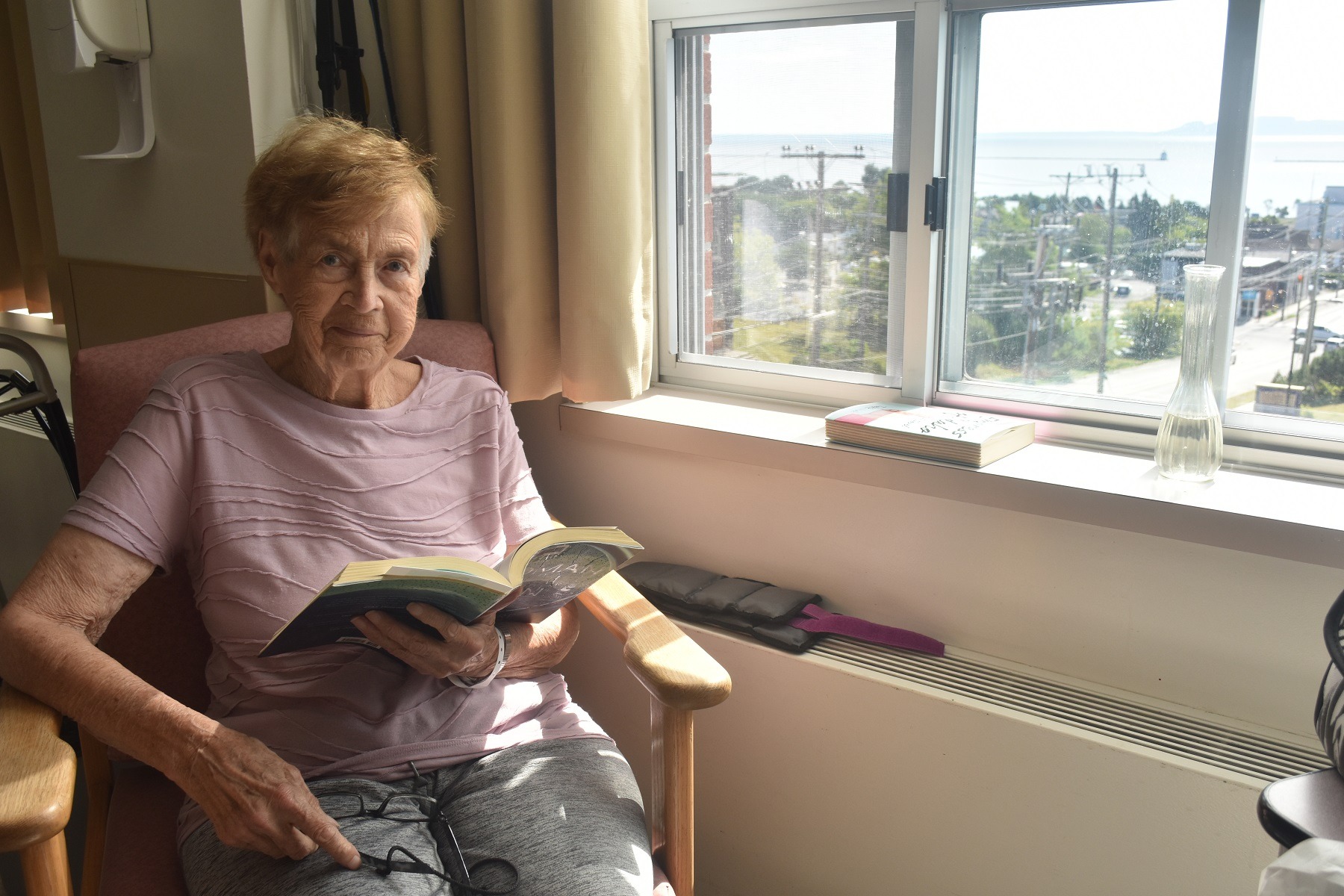 Verna Ross reads a book in her hospital room.