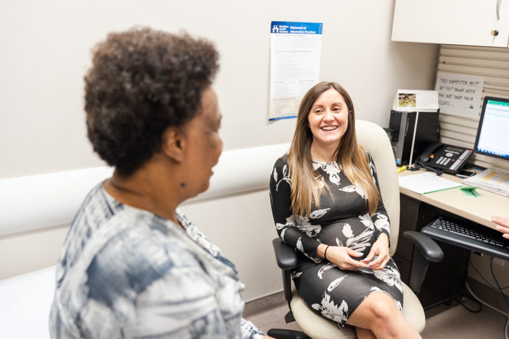 A physician assistant consults with a patient in a doctor's office.