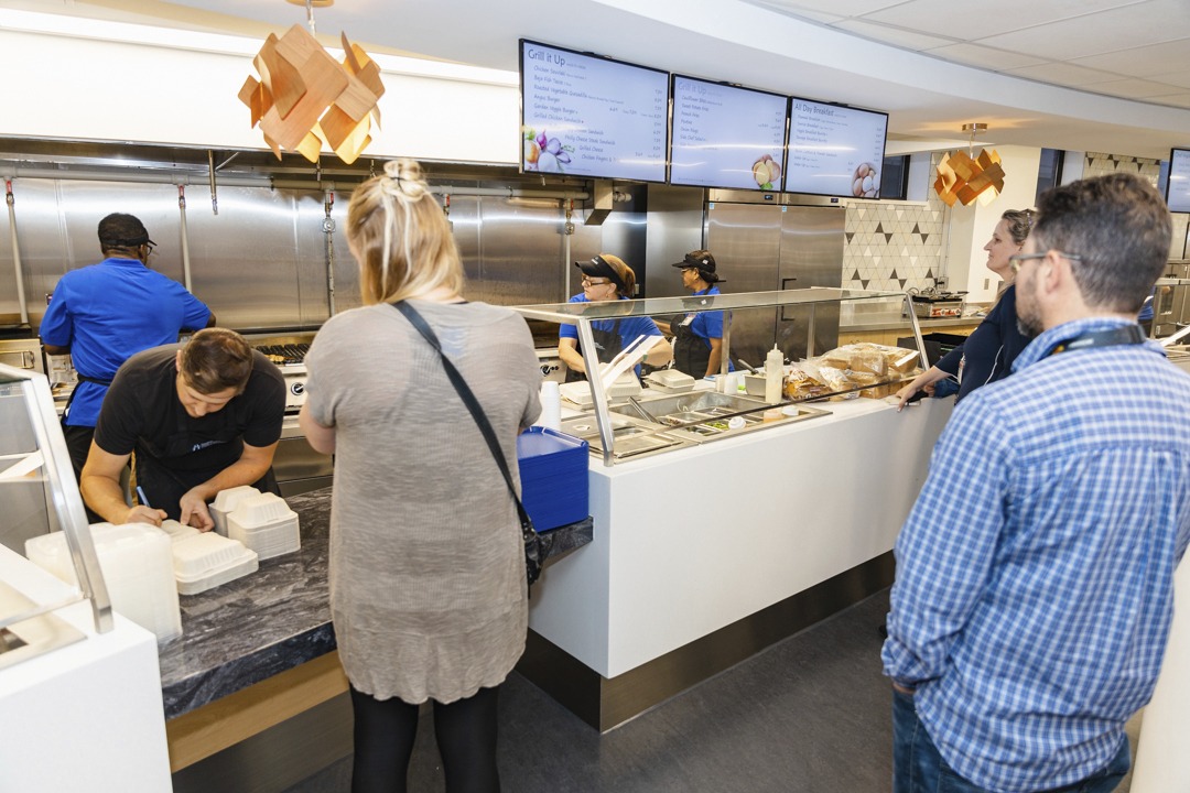 People getting take-out food at a hospital cafeteria