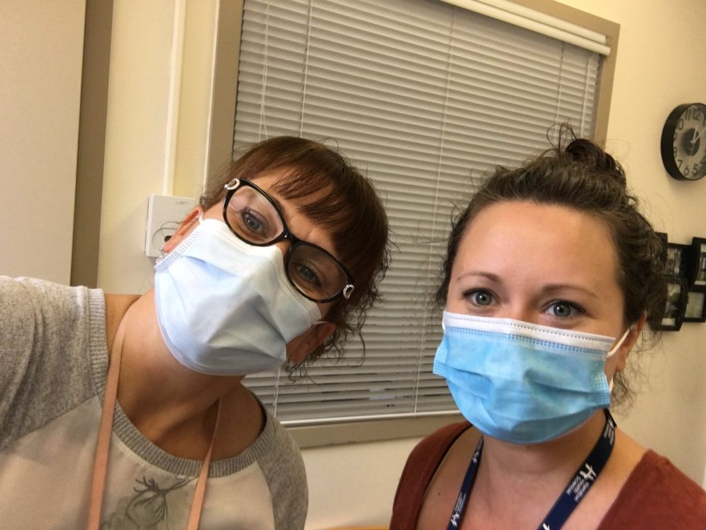 Two female hospital workers wearing disposable masks