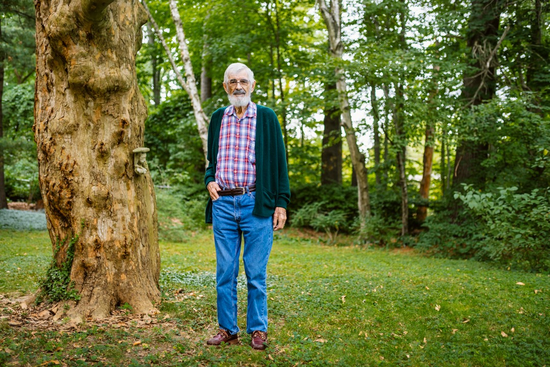 An 80-year-old man who is a Hamilton Health Sciences patient stands beside a mature tree