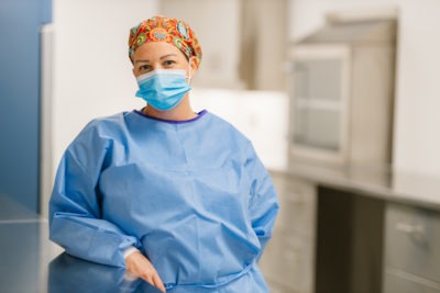Pharmacy technician April Shaw wearing full scrubs and a mask
