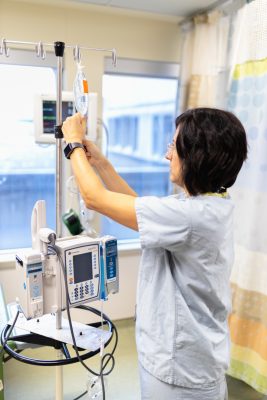 A healthcare worker adjusts an IV