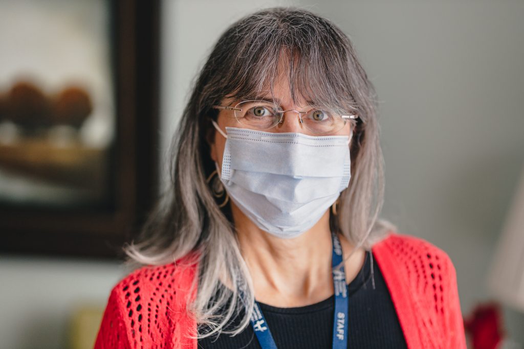 Lisa Petsche smiling at the camera wearing a medical grade face mask