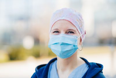 A woman wearing a hospital mask and surgical cap