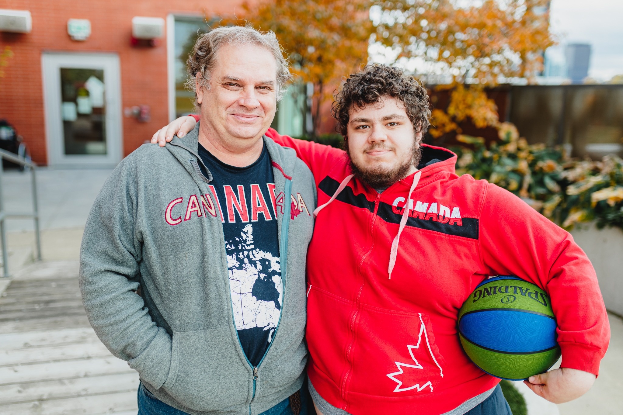 Daniel holding a basketball posing with his dad