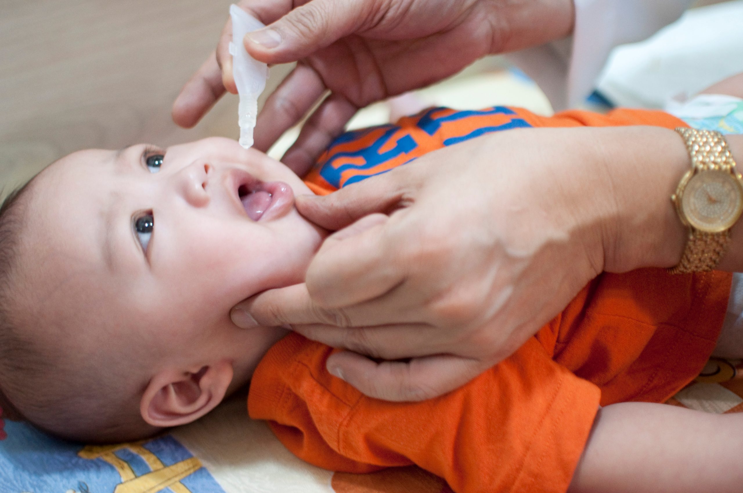 An infant receives an oral vaccination