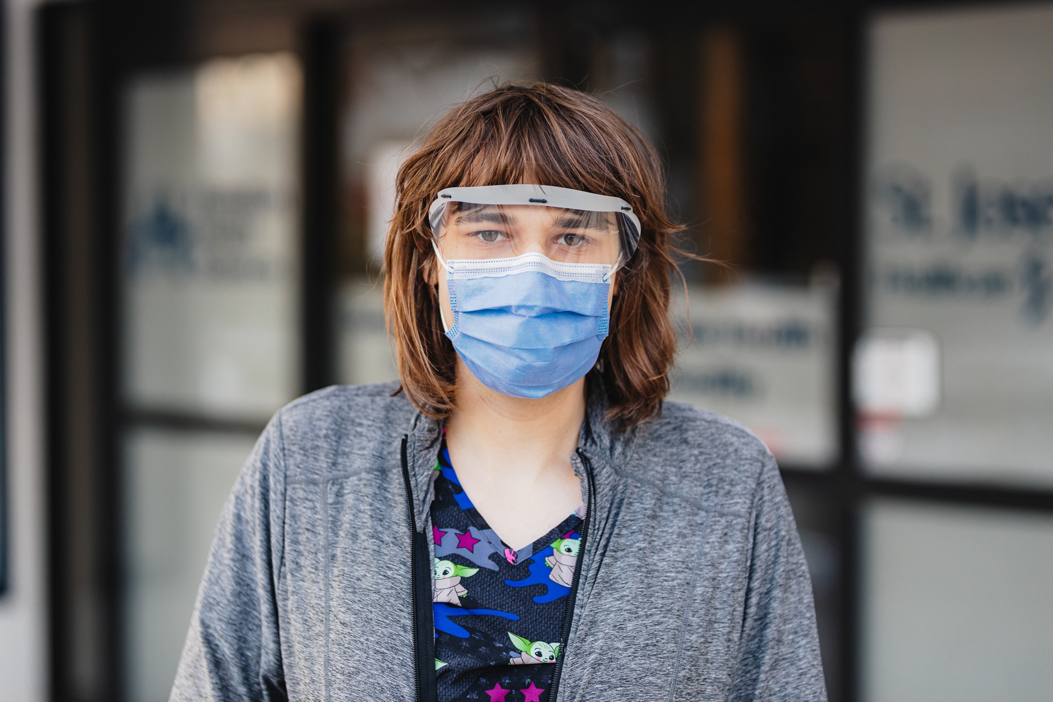 A nurse wears a mask and glasses outside the Satellite Health Facility