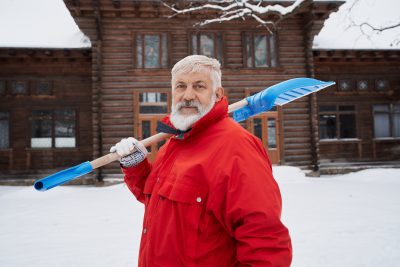 man with snow shovel on shoulder