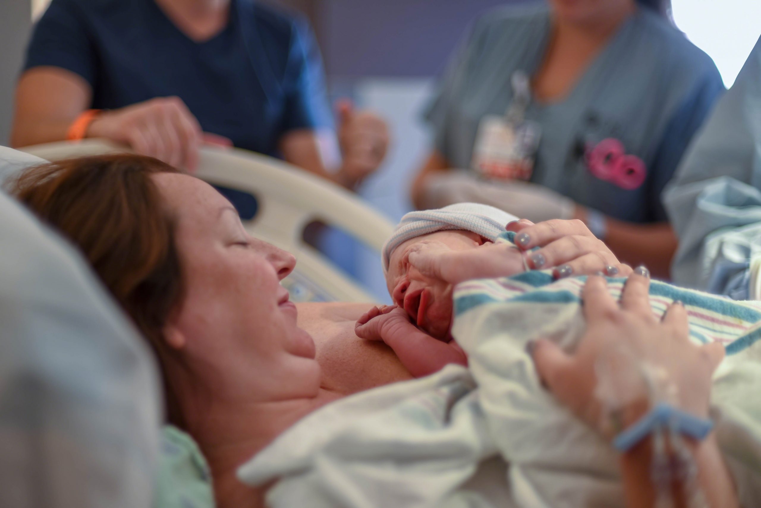 Mother holding baby in hospital bed after birth
