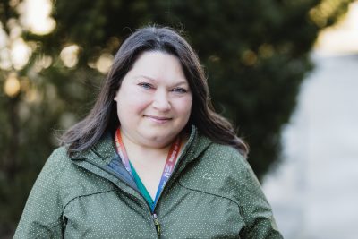 Headshot of Shana Lewis-Hickey, outdoors in a green jacket