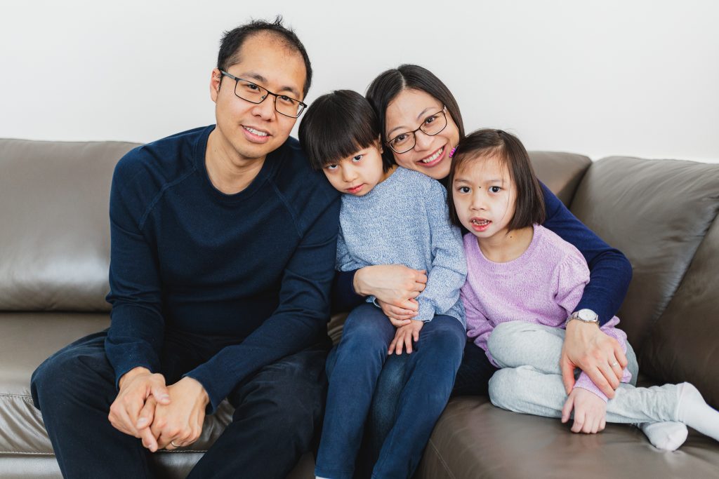 The Wong family cuddling together on a sofa