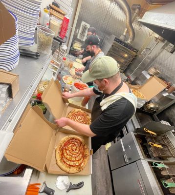 Restaurant workers box take-out pizza