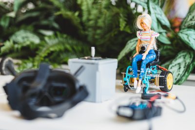 A barbie doll is attached to a remote control car