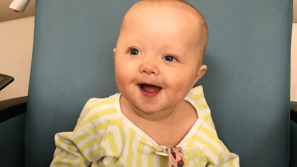 Smiling baby in a yellow hospital gown