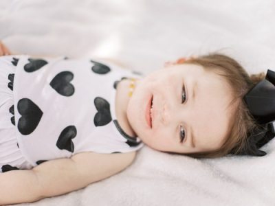 Sawyer Boyce, a child, wears a white dress with black polka-dot hearts