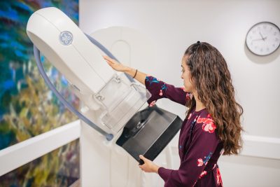 A mammogram technologist with a mammography machine