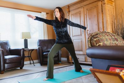 A woman does yoga in a sitting room