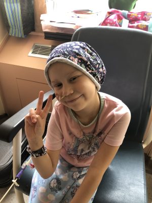 A child receiving cancer treatment in Toronto sits in a hospital bed