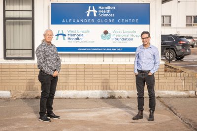 Dr. Stephen Webb (left) and Dr. Christopher Conley standing by a sign for Hamilton Health Sciences' Alexander Globe Centre