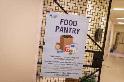 A poster promoting the food pantry program at McMaster Children's Hospital is displayed on an interior gateway
