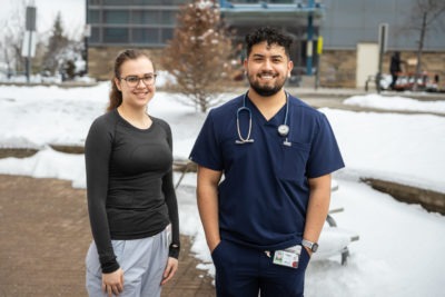 Nursing students Tatiana Gajcevic and Fernando Naranjo, standing outdoors, smiling. While in school, they’ve been gaining valuable work experience as nursing externs at our Hamilton General Hospital.