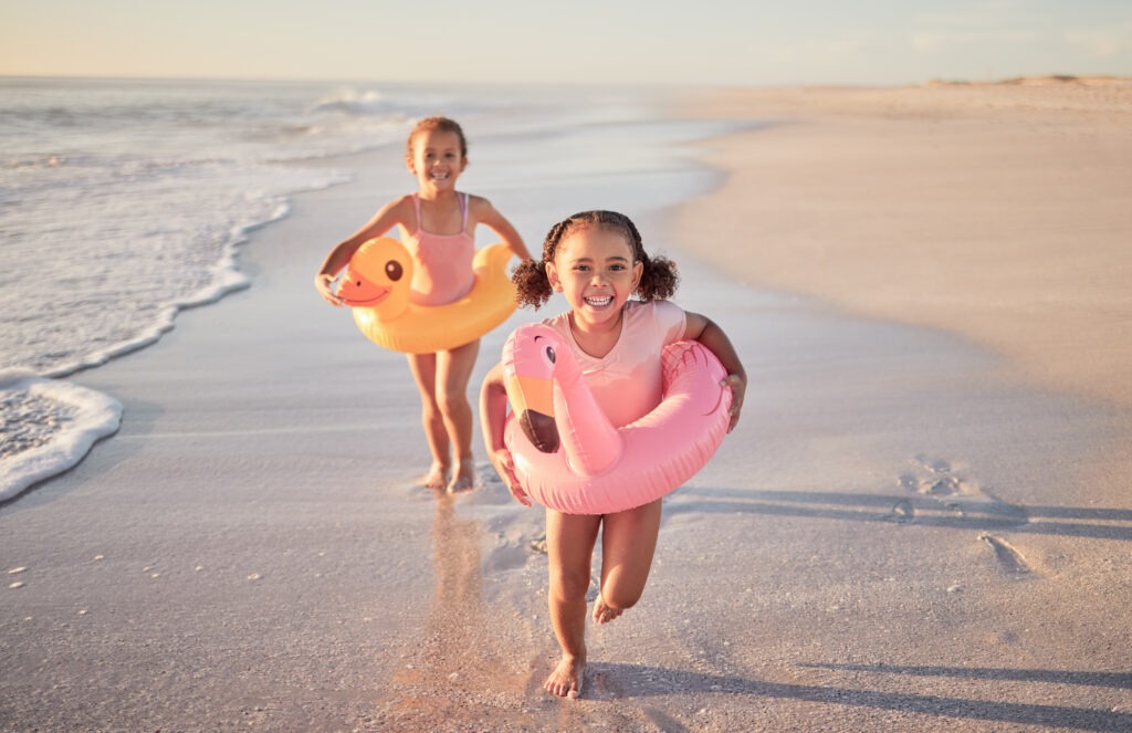 two girls running on the beach