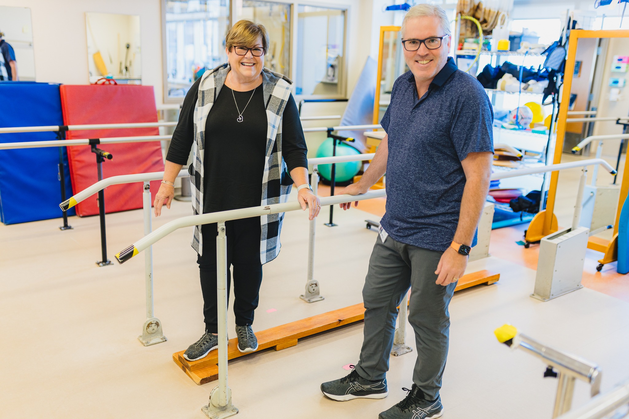 A patient stands in a a gym at the HHS Regional Rehabilitation Centre, with physiotherapist Mike Finlay.