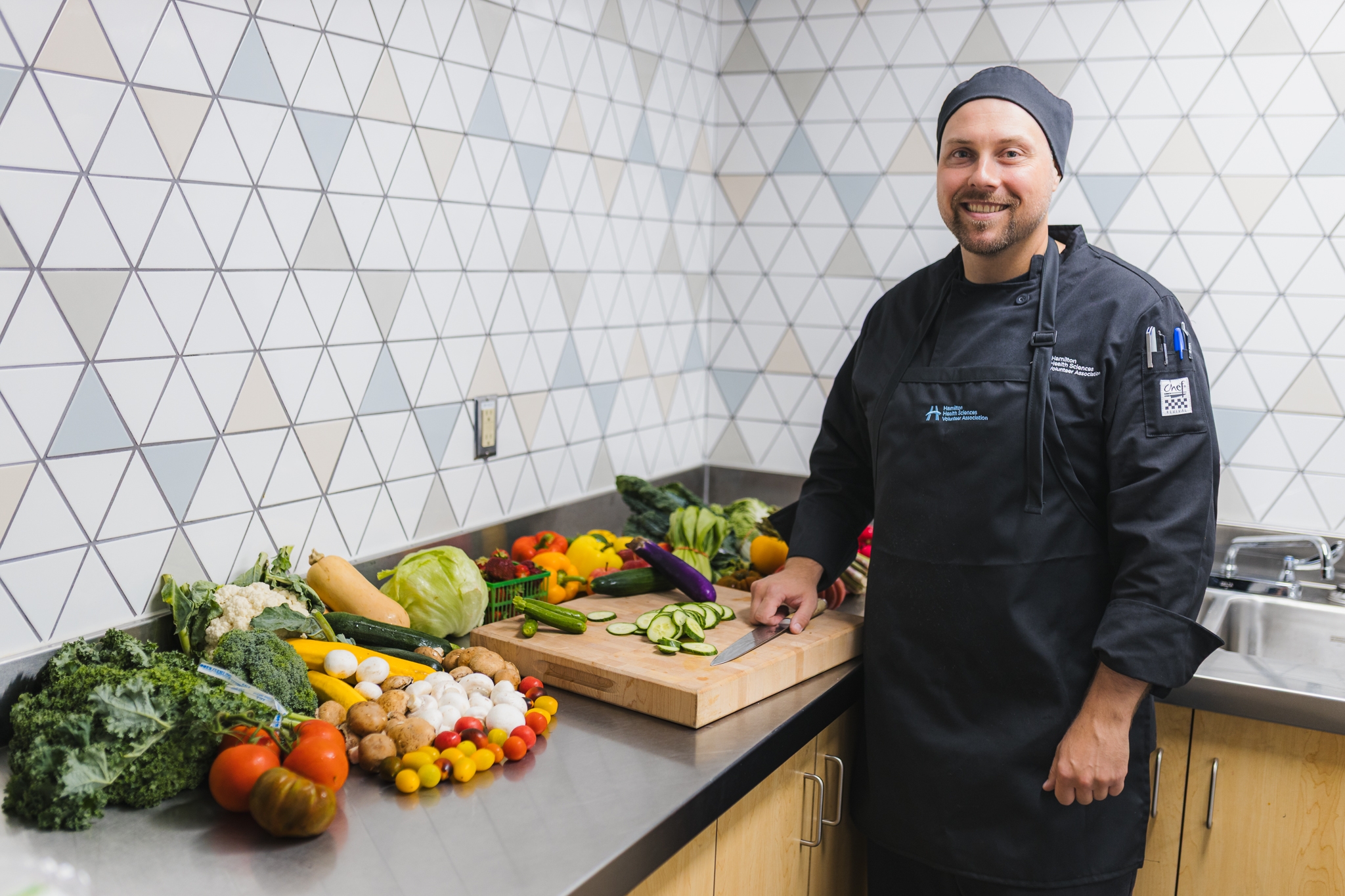 Bogdan Kopec is the chef manager for the Hamilton Health Sciences Volunteer Association, which operates hospital cafeterias and cafes. One way HHS is working to reduce greenhouse gas emissions from food waste is by sourcing local produce. Local food procurement cuts down on transportation emissions, while also supporting local businesses and encouraging seasonal eating.