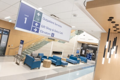 A hospital lobby with seating and a large staircase